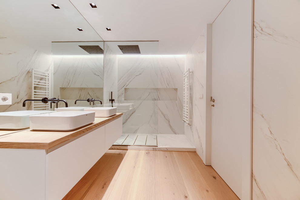 Inspiration for a mid-sized contemporary master bathroom in Other with flat-panel cabinets, white cabinets, an open shower, white tile, marble, white walls, a vessel sink, wood benchtops, brown floor, light hardwood floors, an open shower and brown benchtops.