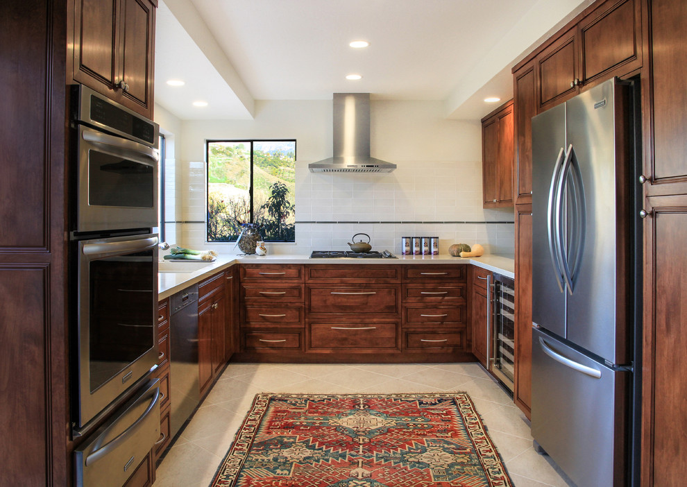 Photo of a traditional u-shaped separate kitchen in Santa Barbara with beige splashback, stainless steel appliances and recessed-panel cabinets.