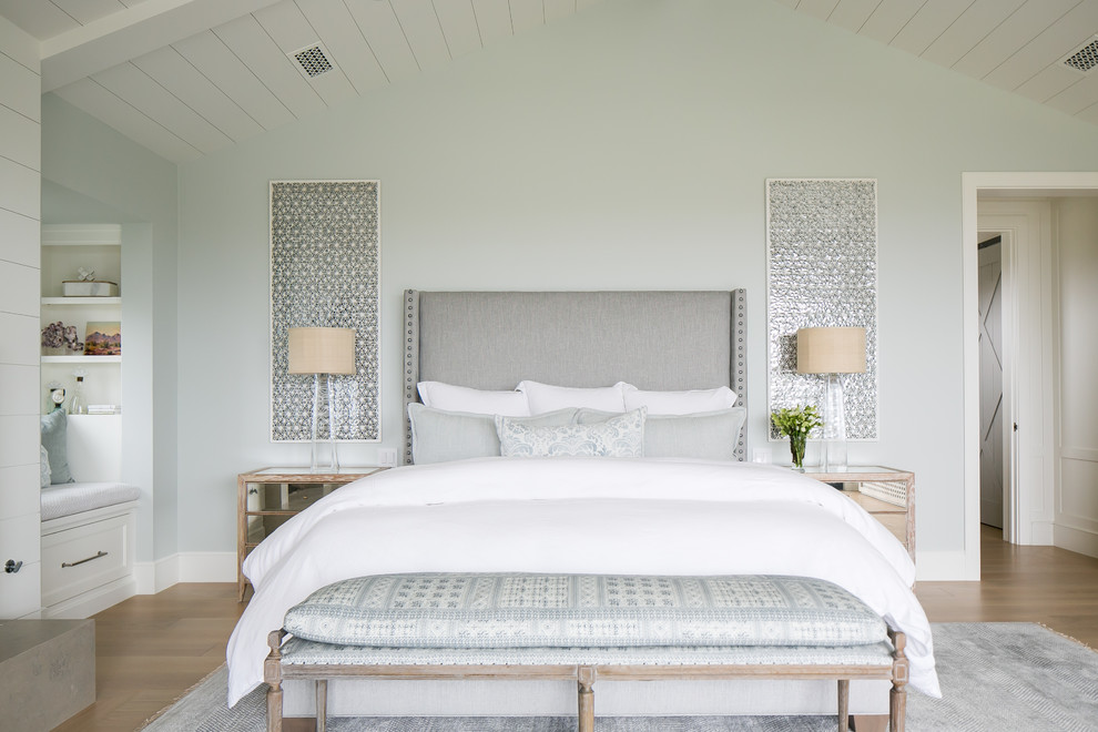 Inspiration for a beach style bedroom in Orange County with green walls, light hardwood floors and brown floor.