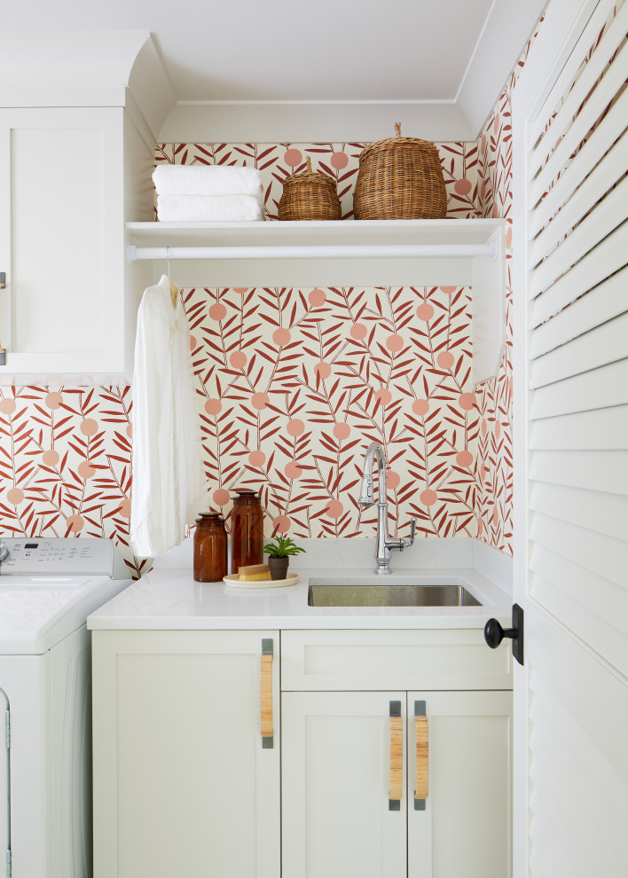 Inspiration for a country single-wall dedicated laundry room in New York with an undermount sink, shaker cabinets, white cabinets, quartz benchtops, multi-coloured walls, a side-by-side washer and dryer, white benchtop and wallpaper.