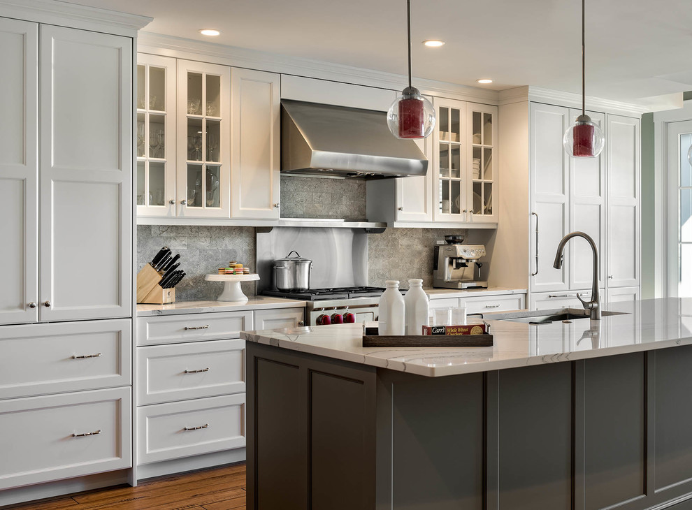 Photo of a large transitional galley eat-in kitchen in Boston with an undermount sink, shaker cabinets, white cabinets, grey splashback, stainless steel appliances, medium hardwood floors, with island, quartz benchtops and limestone splashback.