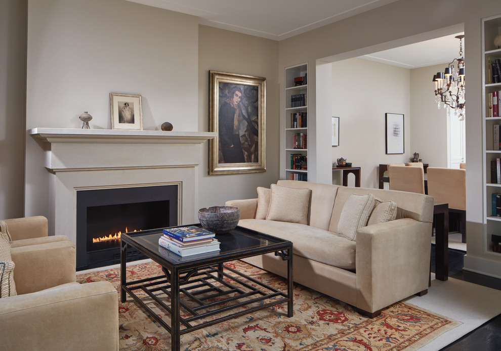 Photo of a mid-sized transitional enclosed living room in DC Metro with a library, beige walls, dark hardwood floors, a standard fireplace, a metal fireplace surround, no tv and brown floor.