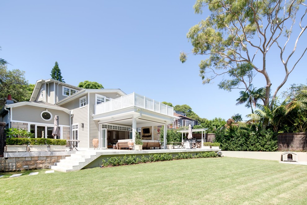 This is an example of an expansive traditional three-storey exterior in Sydney with wood siding and a gable roof.