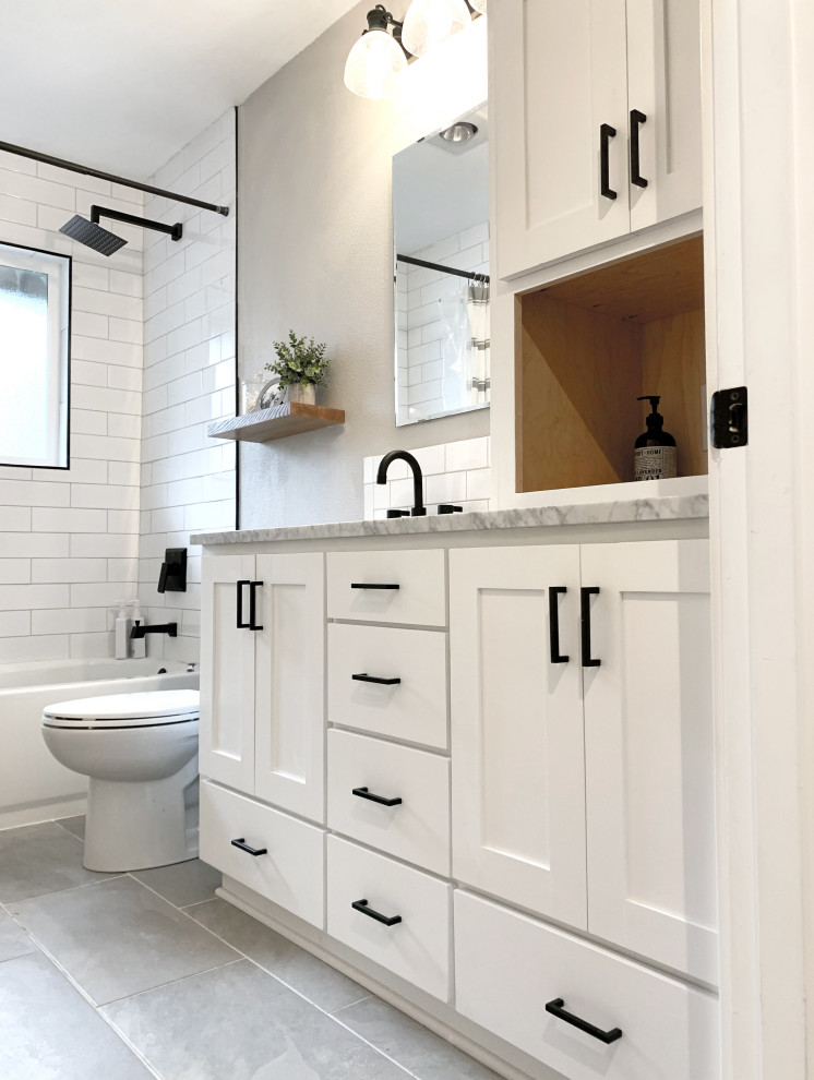 На фото: маленькая ванная комната в стиле неоклассика (современная классика) с фасадами в стиле шейкер, белыми фасадами, накладной ванной, душем над ванной, унитазом-моноблоком, белой плиткой, керамической плиткой, серыми стенами, полом из керамогранита, душевой кабиной, врезной раковиной, мраморной столешницей, серым полом, шторкой для ванной, белой столешницей, тумбой под одну раковину, встроенной тумбой и панелями на стенах для на участке и в саду с