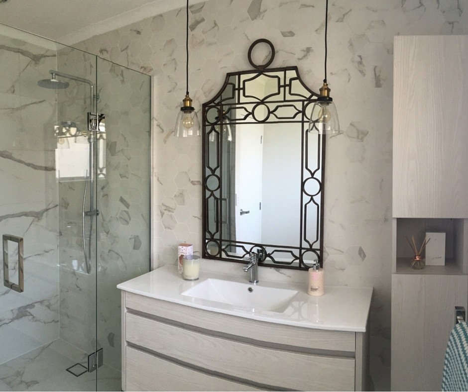 Mid-sized eclectic master bathroom in Auckland with flat-panel cabinets, light wood cabinets, an alcove shower, white tile, porcelain tile, white walls, porcelain floors, a wall-mount sink and solid surface benchtops.