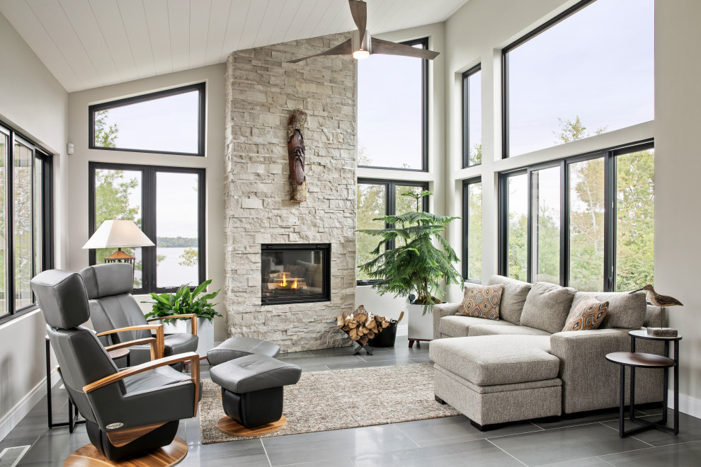 Photo of a mid-sized contemporary open concept family room in Other with white walls, a standard fireplace, a stone fireplace surround, no tv, grey floor and porcelain floors.