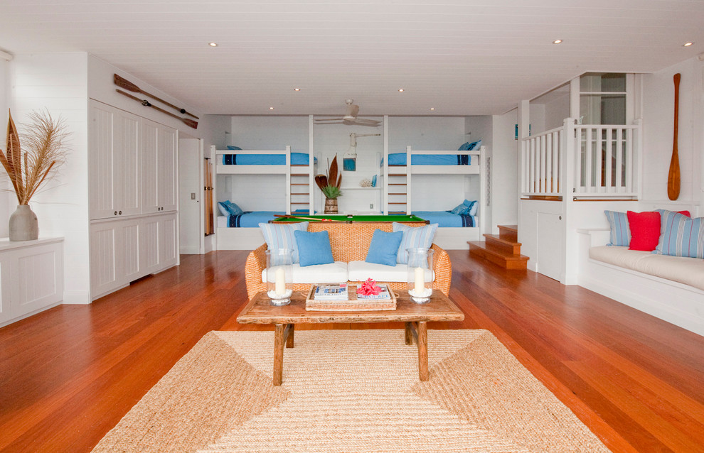 This is an example of a large beach style gender-neutral kids' bedroom in Sydney with white walls and medium hardwood floors.