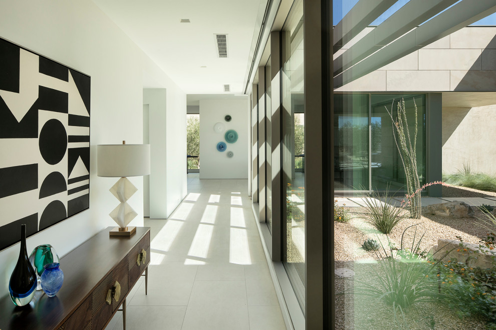 Стильный дизайн: большой коридор в стиле модернизм с белыми стенами, полом из керамической плитки и белым полом - последний тренд