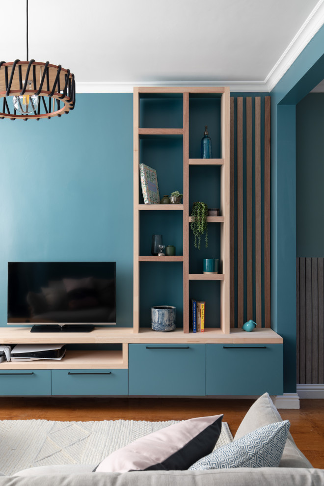 Exemple d'un salon de taille moyenne et ouvert avec un mur bleu, un sol en bois brun, un téléviseur encastré et un sol marron.