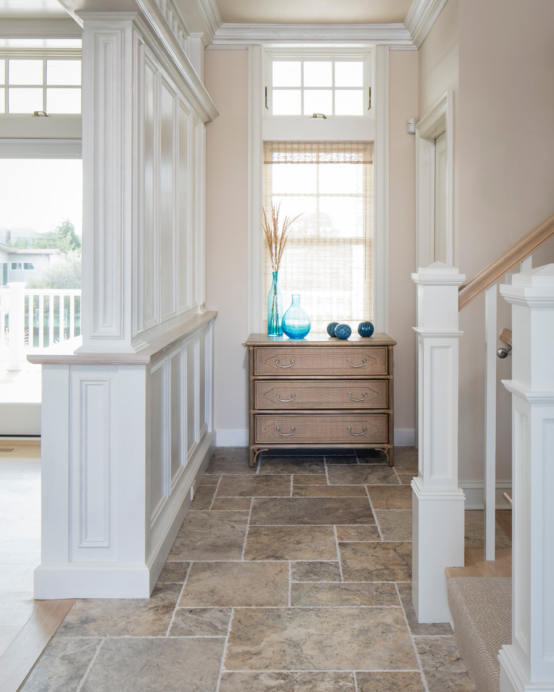 This is an example of a small transitional entry hall in New York with beige walls, limestone floors, a double front door, a dark wood front door and beige floor.