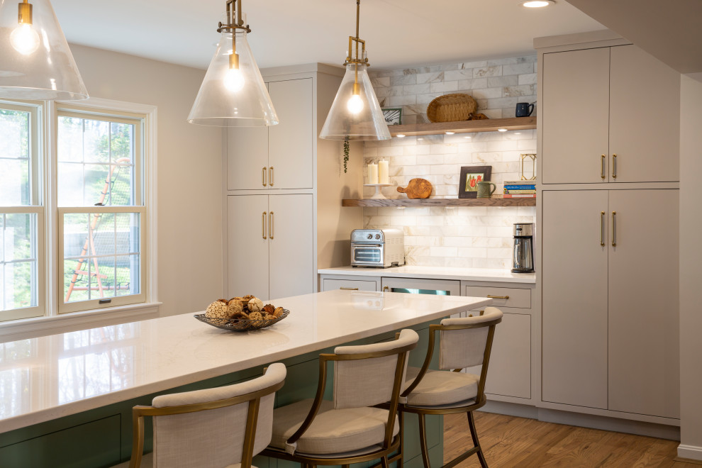 Eat-in kitchen - mid-sized transitional l-shaped medium tone wood floor eat-in kitchen idea in Cincinnati with an undermount sink, beige cabinets, quartz countertops, marble backsplash, stainless steel appliances, an island and white countertops