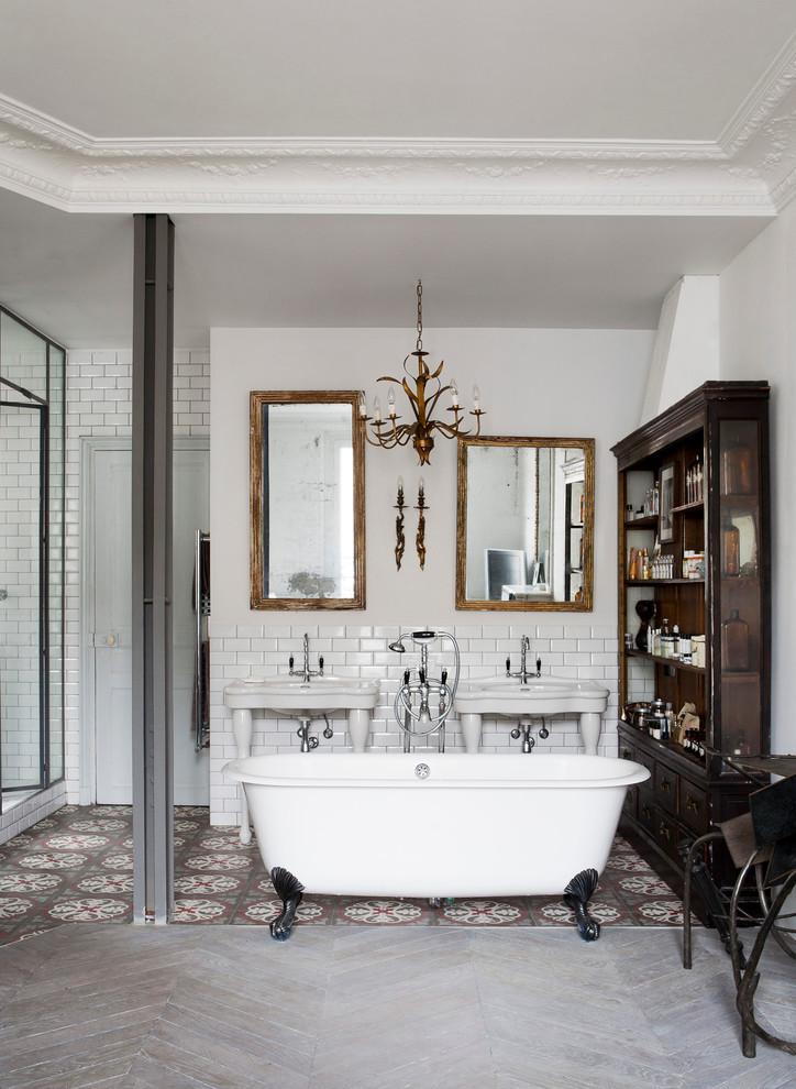 Inspiration for a large eclectic master bathroom in Paris with a claw-foot tub, white tile, subway tile, white walls, light hardwood floors, a console sink and a corner shower.