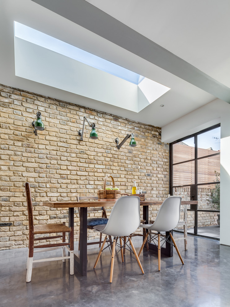 Photo of a mid-sized contemporary dining room in London with concrete floors.
