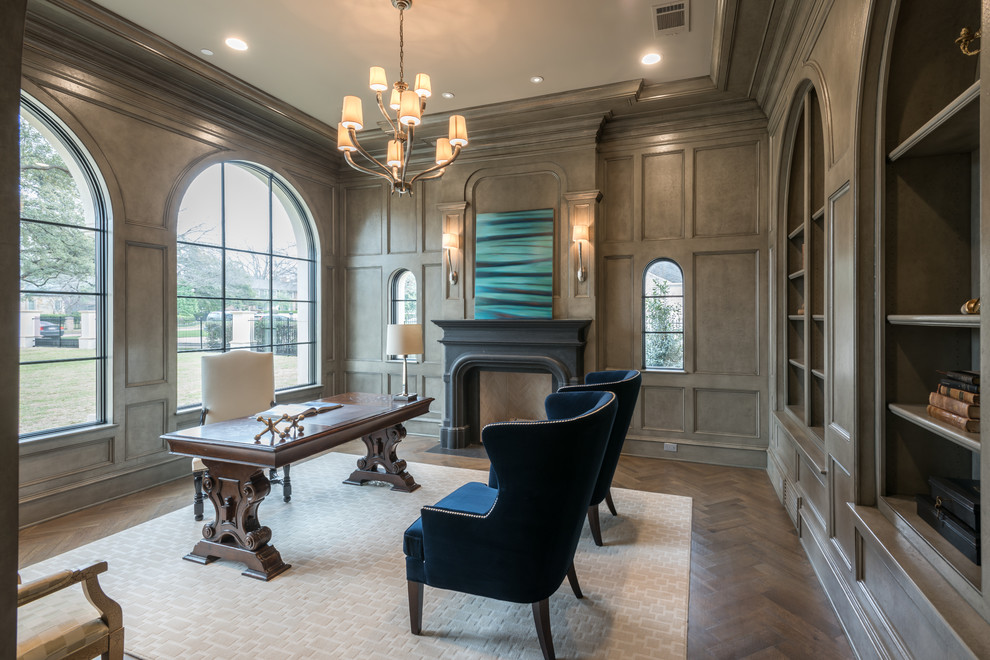 Design ideas for an expansive traditional home office in Dallas with a library, grey walls, medium hardwood floors, a stone fireplace surround and a freestanding desk.