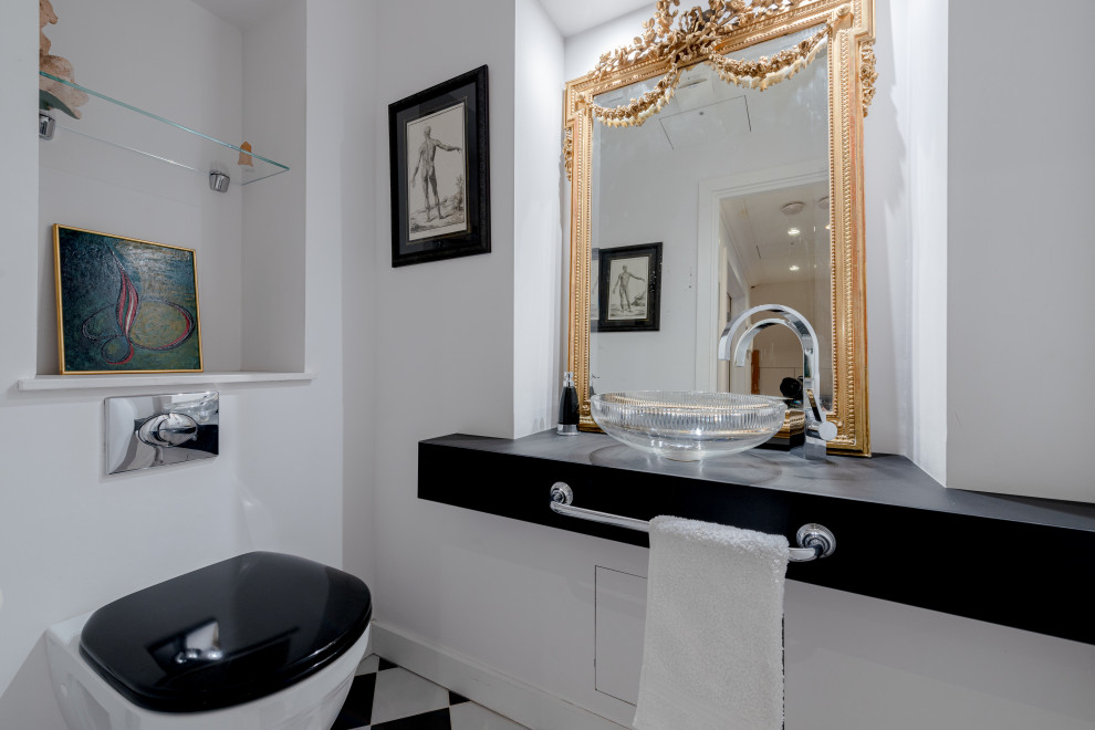 Стильный дизайн: туалет среднего размера в стиле фьюжн с инсталляцией, белыми стенами, мраморным полом, настольной раковиной, черной столешницей и встроенной тумбой - последний тренд