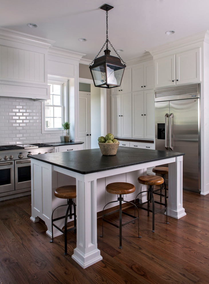 Inspiration for a transitional l-shaped kitchen in Charlotte with shaker cabinets, white cabinets, white splashback, subway tile splashback, stainless steel appliances, dark hardwood floors and with island.