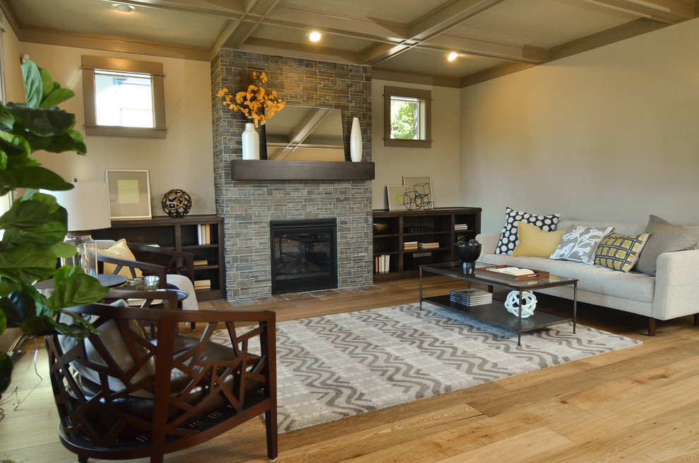 Photo of a mid-sized contemporary open concept family room in Portland with beige walls, medium hardwood floors, a tile fireplace surround, no tv and a standard fireplace.