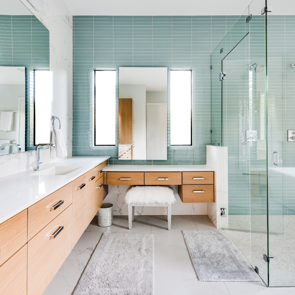 Photo of a contemporary master bathroom in Dallas with flat-panel cabinets, medium wood cabinets, a corner shower, blue tile, glass tile, an undermount sink, grey floor and white benchtops.