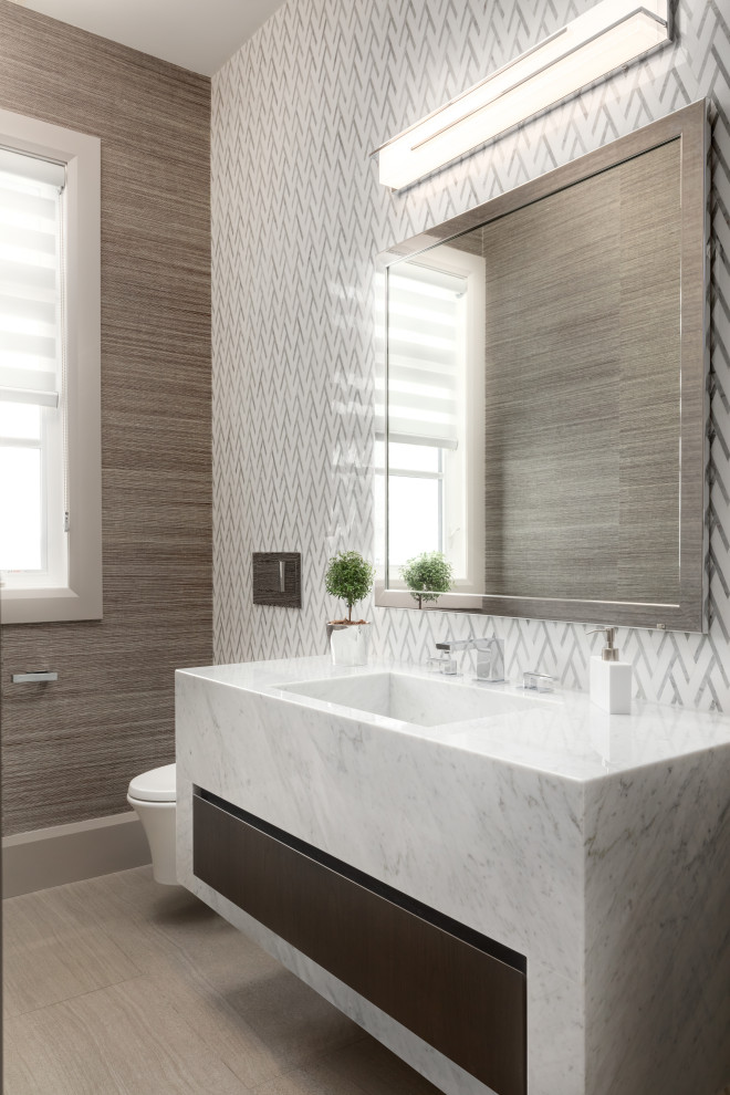 Exempel på ett mellanstort modernt vit vitt toalett, med släta luckor, vita skåp, en toalettstol med hel cisternkåpa, vit kakel, mosaik, bruna väggar, ett integrerad handfat och marmorbänkskiva