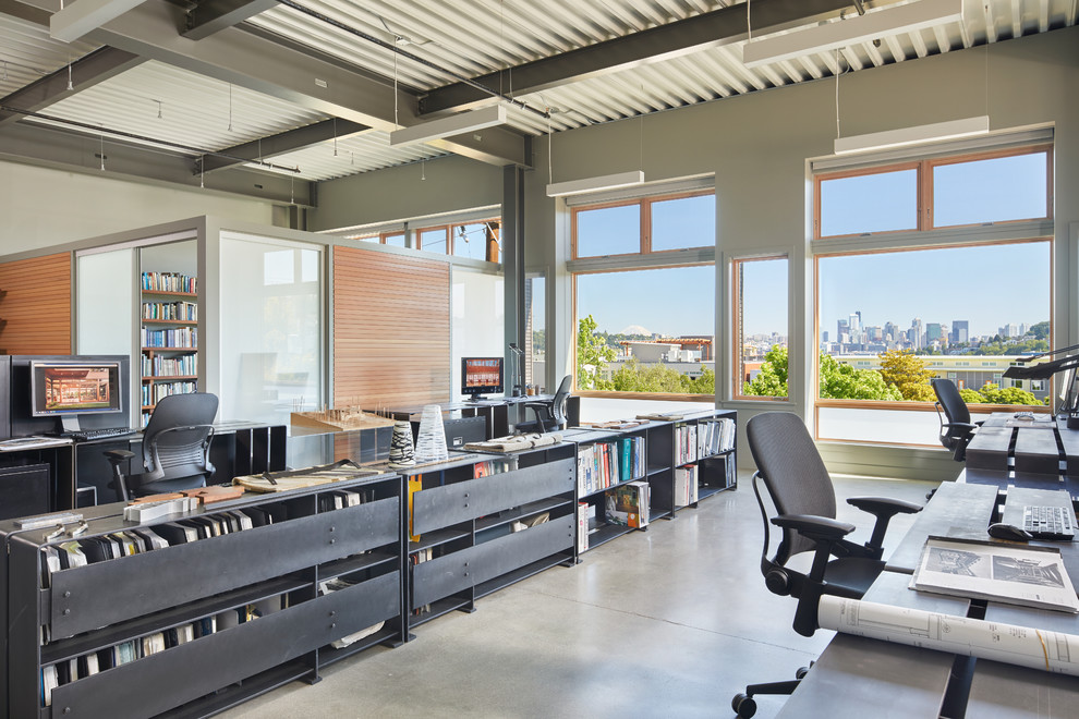 This is an example of a large modern home office in Seattle with concrete floors and grey floor.