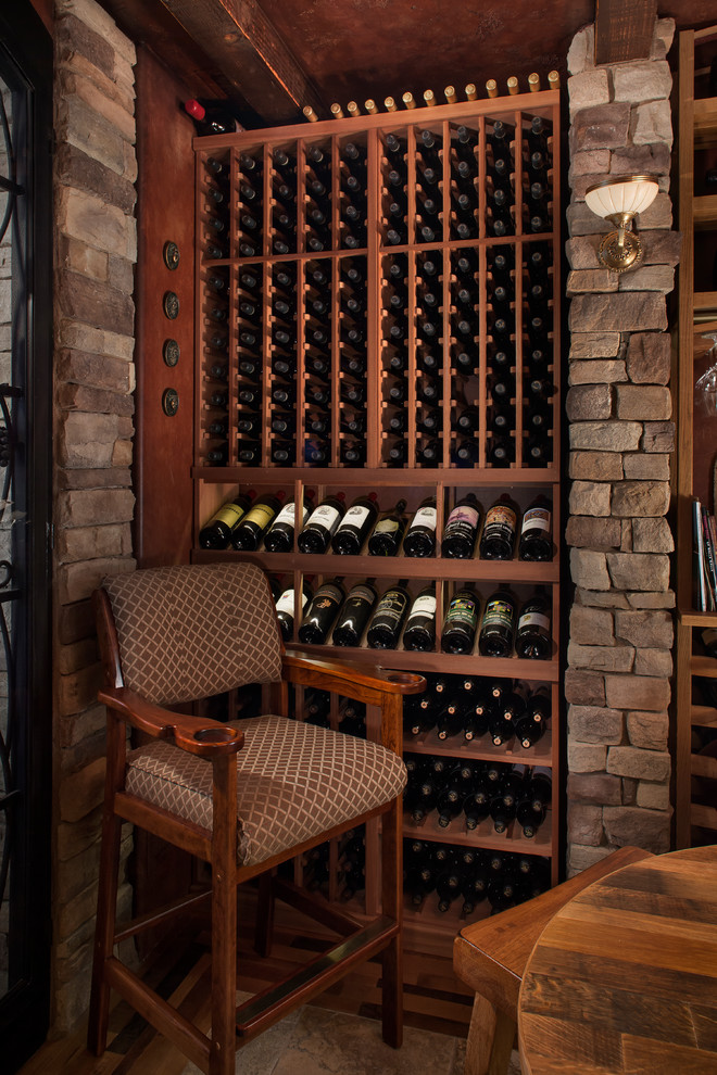 Inspiration for a mid-sized country wine cellar in Phoenix with storage racks, beige floor and slate floors.