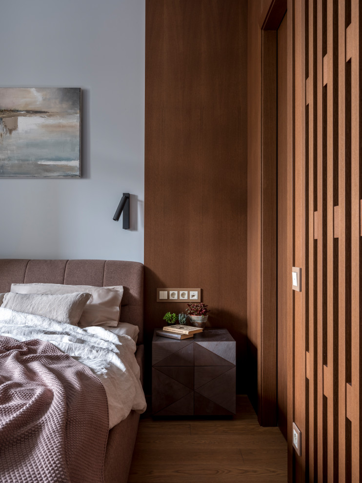 This is an example of a small classic master bedroom in Moscow with blue walls, medium hardwood flooring and brown floors.