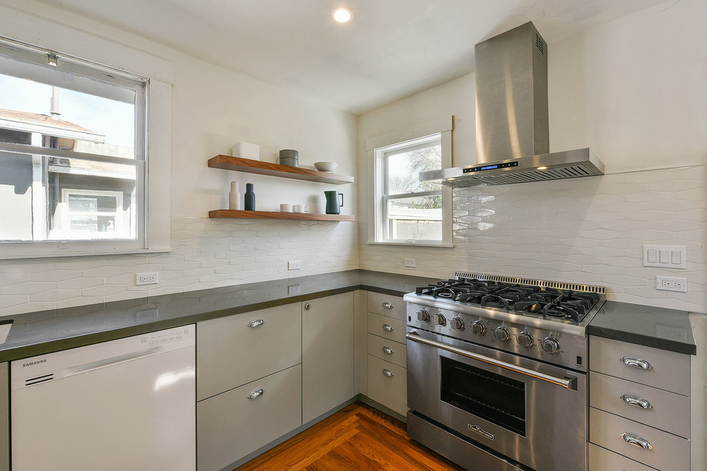 Mid-sized transitional galley light wood floor and beige floor enclosed kitchen photo in San Francisco with flat-panel cabinets, beige cabinets, quartz countertops, white backsplash, ceramic backsplash, stainless steel appliances and no island