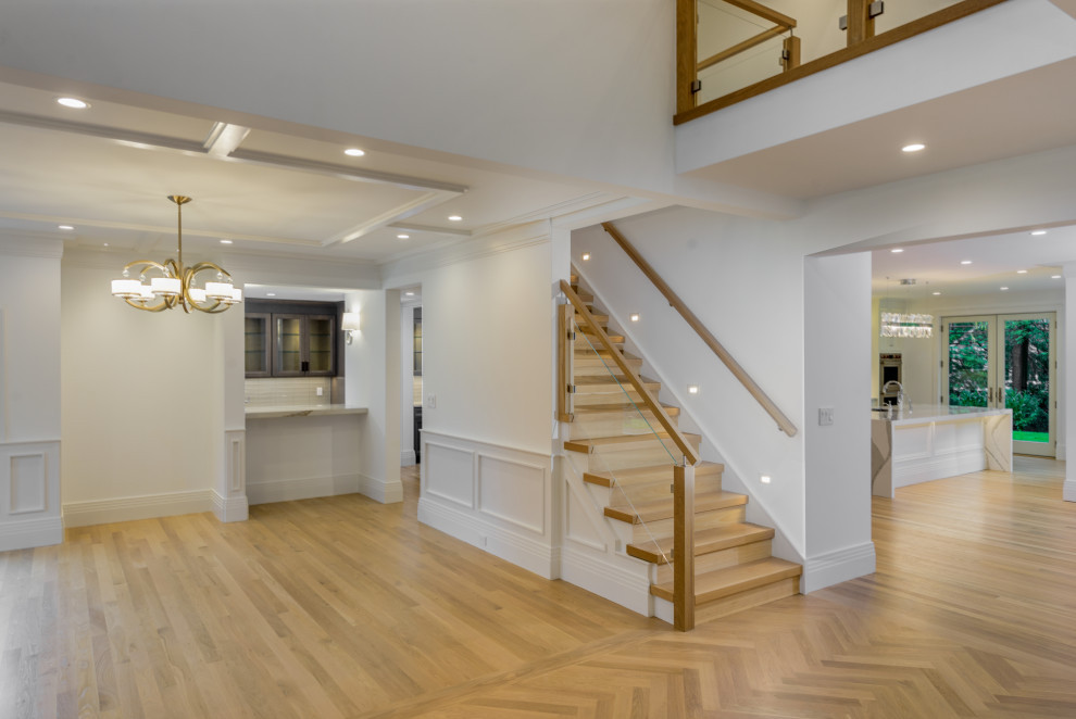 Design ideas for an expansive contemporary foyer in New York with white walls, light hardwood floors, a single front door and a dark wood front door.