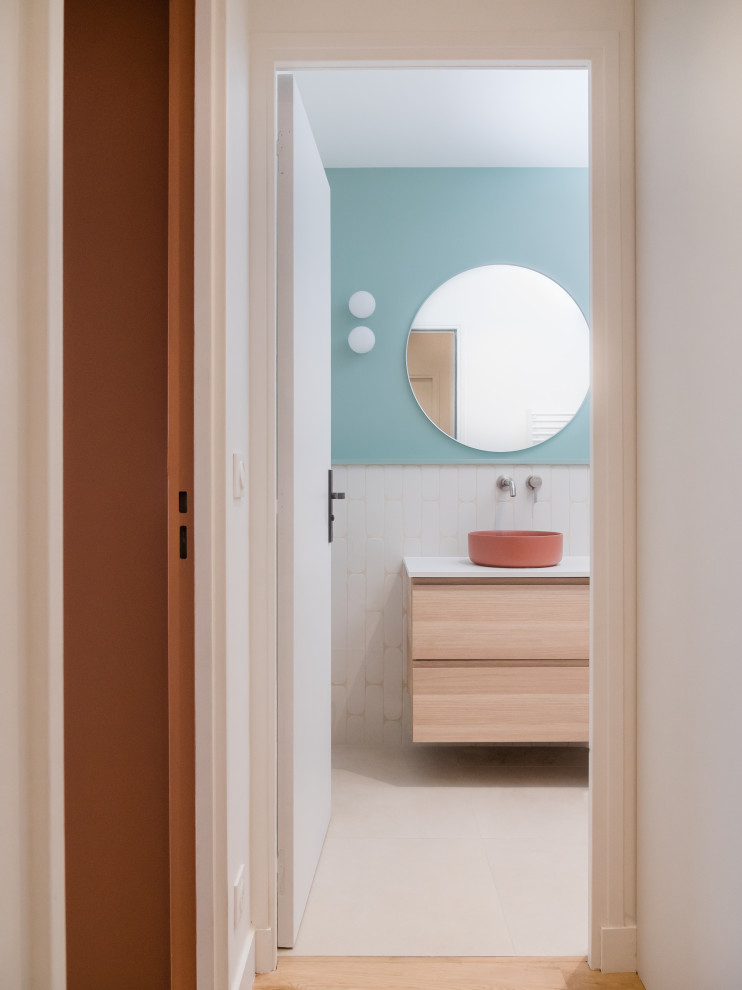 Idée de décoration pour une salle de bain beige et blanche minimaliste en bois clair de taille moyenne pour enfant avec un combiné douche/baignoire, un carrelage blanc, un mur bleu, carreaux de ciment au sol, un lavabo posé, un sol gris, un plan de toilette blanc, du carrelage bicolore, meuble simple vasque et meuble-lavabo suspendu.