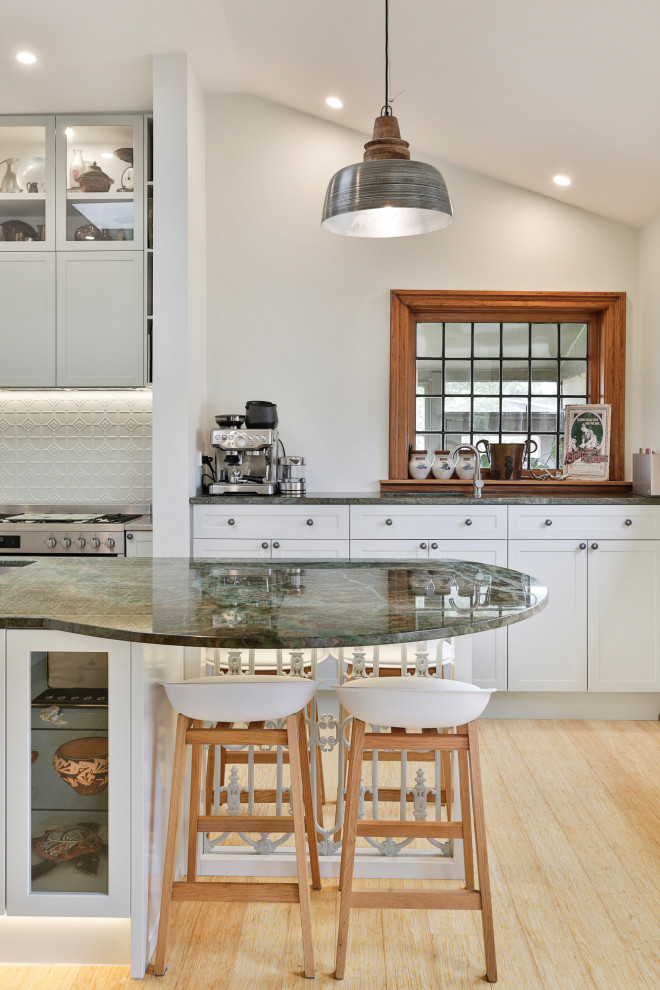 Inspiration for a large traditional l-shaped eat-in kitchen in Christchurch with an undermount sink, shaker cabinets, green cabinets, granite benchtops, green splashback, metal splashback, stainless steel appliances, bamboo floors, with island and green benchtop.