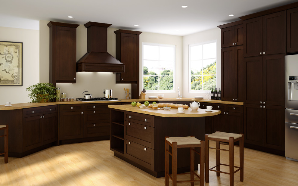 Mid-sized transitional l-shaped light wood floor and beige floor enclosed kitchen photo with dark wood cabinets, wood countertops, stainless steel appliances, an island, an undermount sink and shaker cabinets