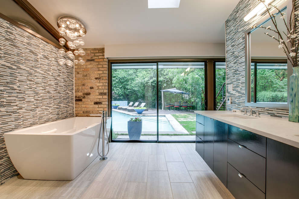 Inspiration for a contemporary master bathroom in Dallas with an undermount sink, flat-panel cabinets, black cabinets, a freestanding tub, multi-coloured tile and matchstick tile.