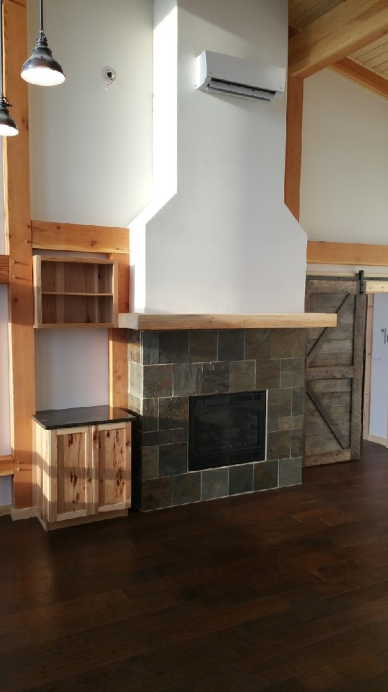 Photo of a mid-sized arts and crafts open concept living room in Seattle with a home bar, white walls, dark hardwood floors, a standard fireplace, a stone fireplace surround, no tv and blue floor.