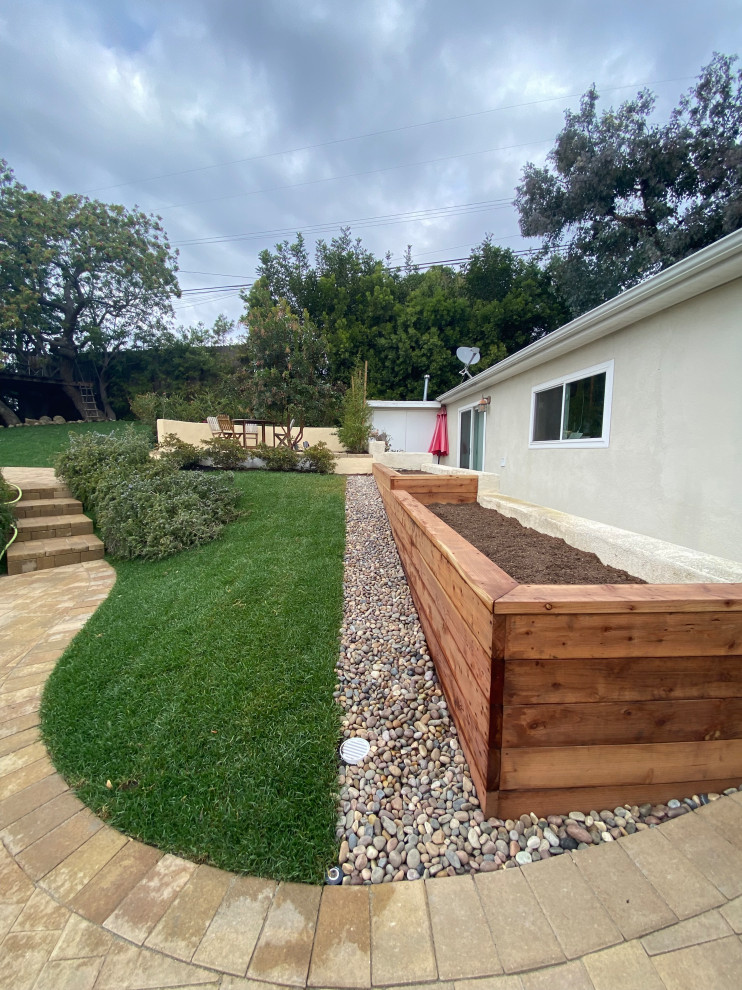Geometrischer, Geräumiger Garten im Frühling, hinter dem Haus mit Hochbeet, direkter Sonneneinstrahlung, Betonboden und Holzzaun in Los Angeles