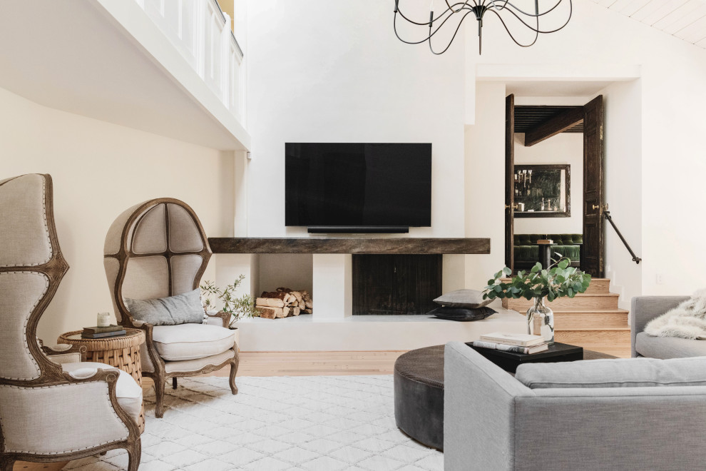 Esempio di un soggiorno mediterraneo con pareti bianche, parquet chiaro, camino classico, TV a parete e pavimento beige