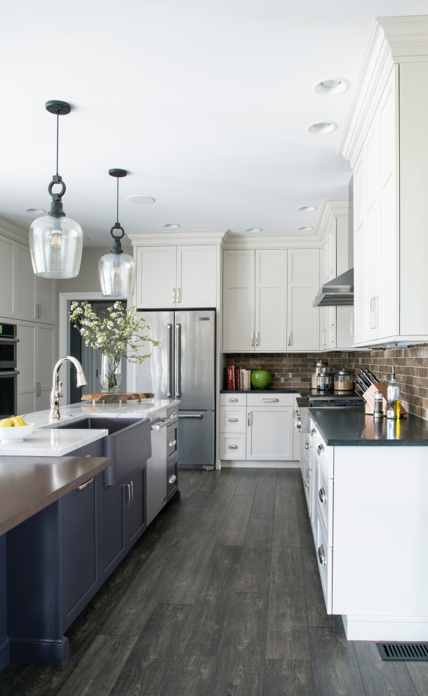 Kitchen - l-shaped gray floor kitchen idea with a farmhouse sink, white cabinets, quartz countertops, beige backsplash, ceramic backsplash, stainless steel appliances and an island