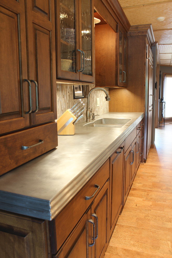 Inspiration for a large transitional cork floor kitchen remodel with raised-panel cabinets, medium tone wood cabinets, glass tile backsplash and an island
