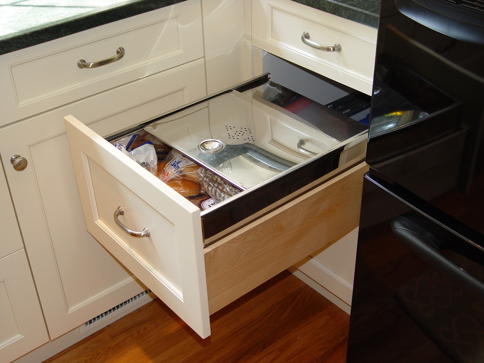 Transitional kitchen photo in Boston with an undermount sink, recessed-panel cabinets, white cabinets, granite countertops, black appliances and an island