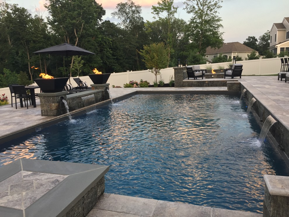 Design ideas for a large contemporary backyard rectangular lap pool in Boston with a water feature and concrete pavers.