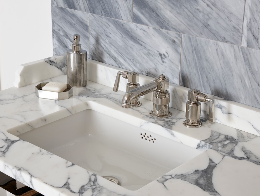 This is an example of a traditional bathroom in London with a drop-in sink, marble benchtops and gray tile.