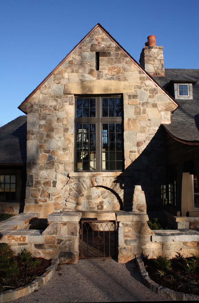 Mid-sized transitional two-storey multi-coloured exterior in Other with stone veneer and a gable roof.