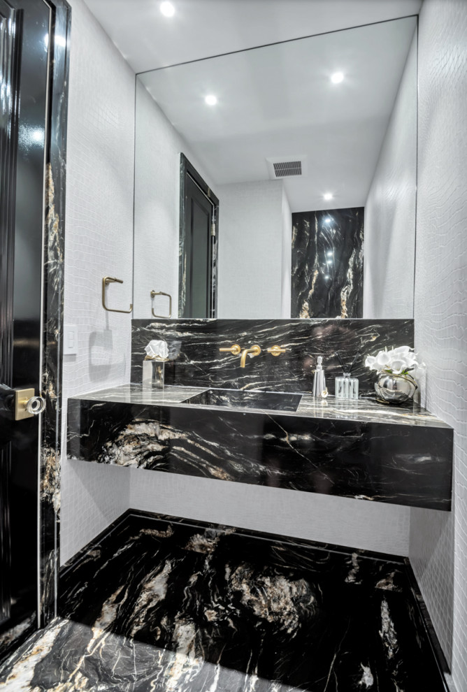 Expansive traditional powder room in New York with furniture-like cabinets, black cabinets, a wall-mount toilet, black tile, marble, beige walls, marble floors, a wall-mount sink, quartzite benchtops, black floor, black benchtops and a floating vanity.