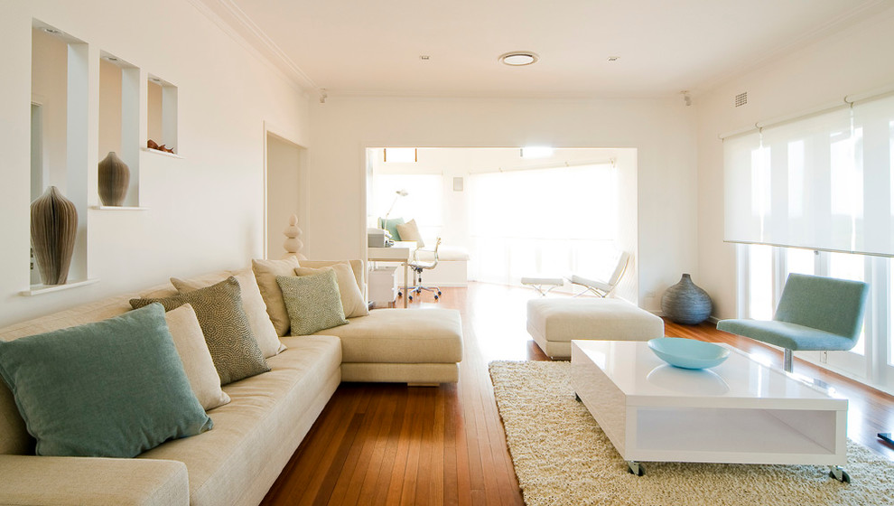 This is an example of a large contemporary living room in Brisbane with white walls and medium hardwood floors.