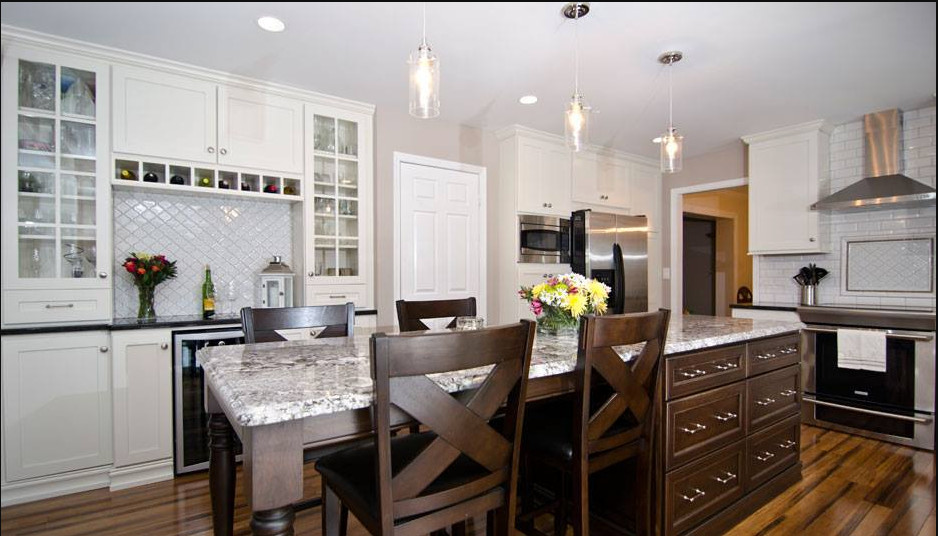 Mid-sized transitional u-shaped medium tone wood floor kitchen photo in Chicago with shaker cabinets, white cabinets, granite countertops, white backsplash, subway tile backsplash, stainless steel appliances and an island