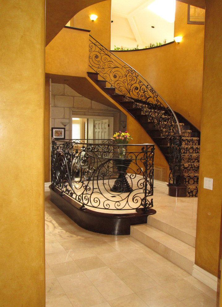 Example of a large tuscan foyer design in Orange County with orange walls