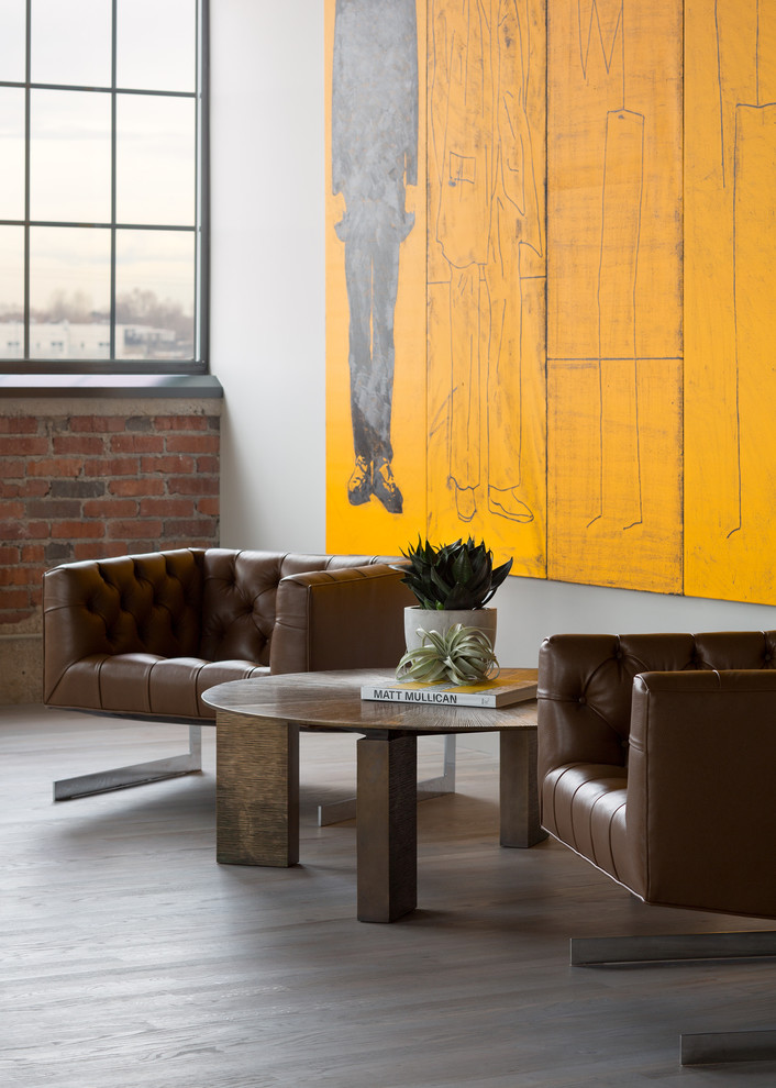Inspiration for an industrial open concept living room in Denver with white walls and light hardwood floors.