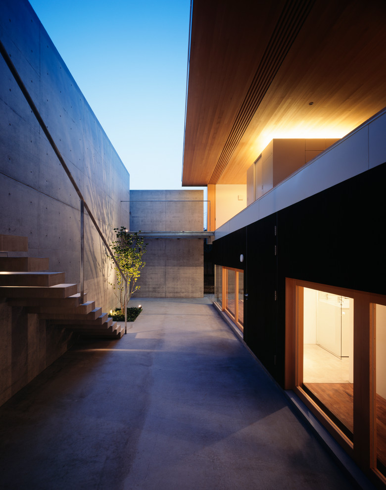 This is an example of a modern backyard patio in Yokohama with a roof extension.