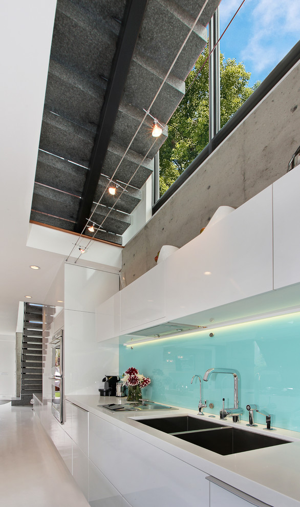 Inspiration for a contemporary open concept kitchen remodel in Orange County with a double-bowl sink, flat-panel cabinets, white cabinets, blue backsplash and glass sheet backsplash