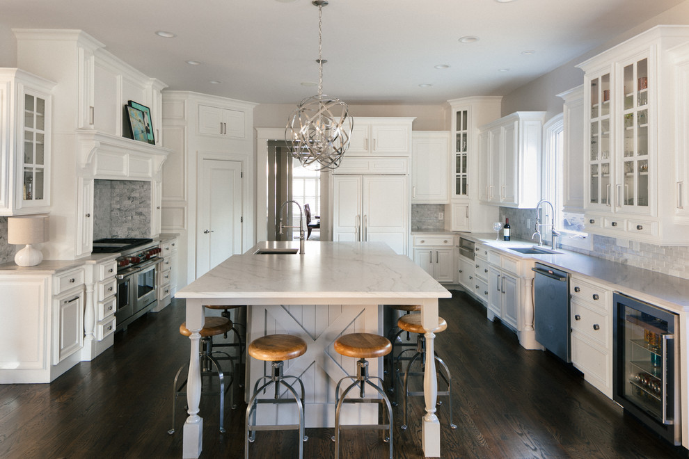 Large transitional u-shaped medium tone wood floor and brown floor eat-in kitchen photo in Atlanta with an undermount sink, raised-panel cabinets, white cabinets, marble countertops, white backsplash, marble backsplash, stainless steel appliances and an island