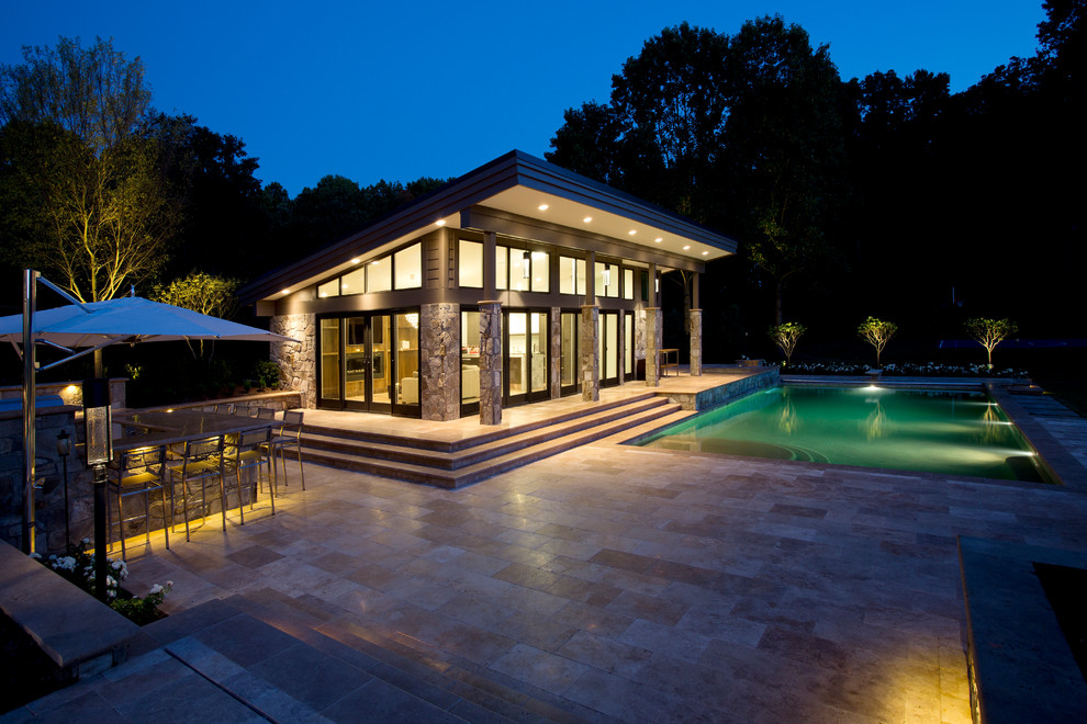 Design ideas for a large traditional backyard pool in DC Metro with natural stone pavers.